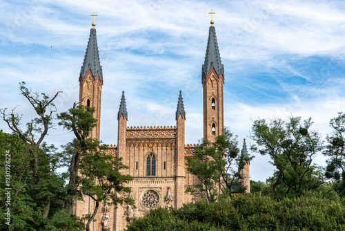 Landscape view of the Palace Church in Neustrelitz, partially hidden behind trees at the edge of the Palace Park, Mecklenburg-Western Pomerania, Germany.