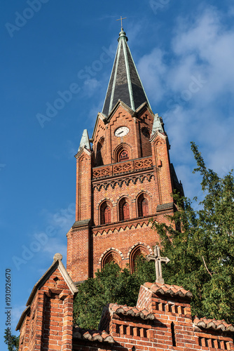 Church tower of St. Mary’s Church in Röbel/Müritz, Germany, sunlit facade with blue sky. Historic landmark in Mecklenburg-Western Pomerania.