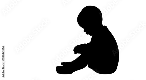 Silhouette of a baby sitting and playing