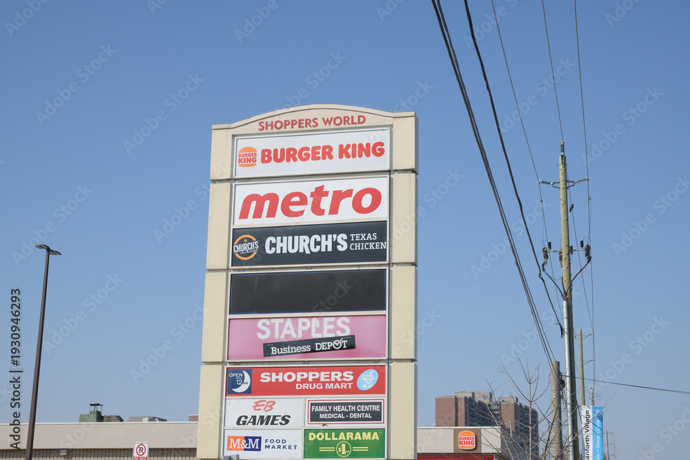 Fototapeta premium pylon road sign at Shoppers World Danforth with business directory (Metro supermarket is located there at 3003 Danforth Av and Victoria Park Av), Toronto