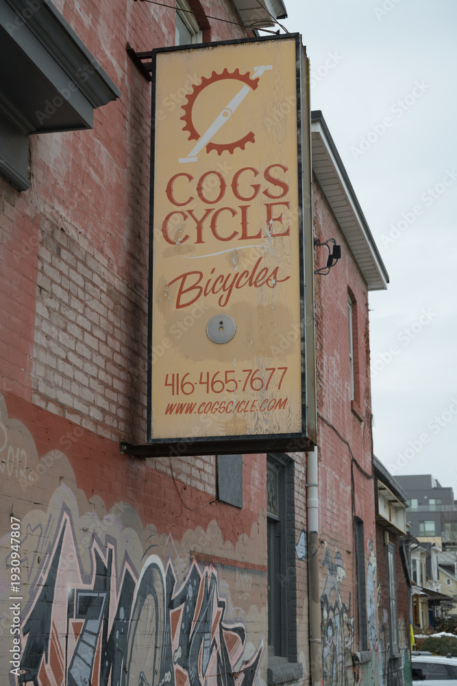 Obraz premium exterior projecting sign of Cogs Cycle located at 1 Howland Rd, on Gerrard St E, Toronto