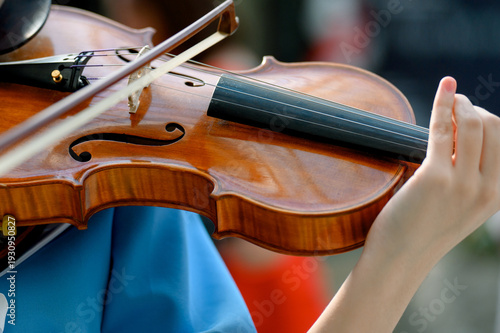 Canvas-taulu Close-up of violin being played by musician in blue shirt outdoors