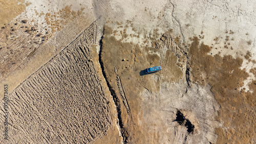 Minimalist aerial composition of pink flamingos in a turquoise mountain lagoon.