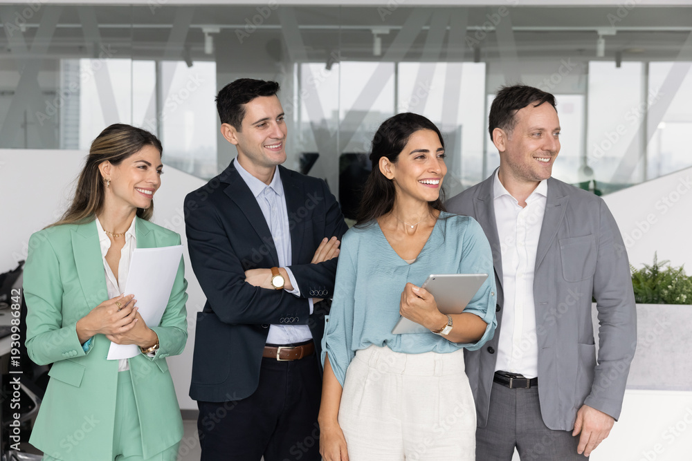 Obraz premium Diverse group of business colleagues company workforce members standing in office smiling looking aside enjoying friendly corporate culture shared goals and values positive vision for future success