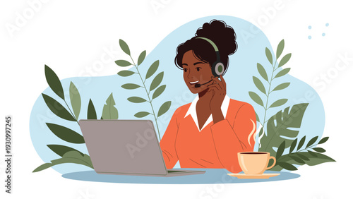 Professional black woman wearing a headset and working on a laptop at her desk with a cup of hot coffee and green plants in the background.