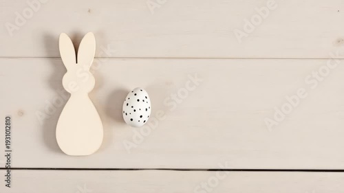 Minimal easter bunny decor with polka dot egg on wooden background
