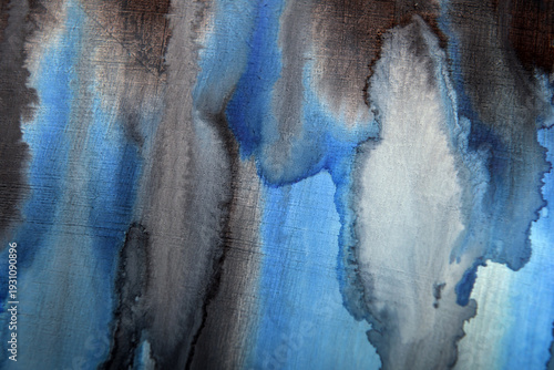 a dark background of blue stains on a worn surface