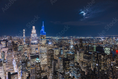 Night aerial view of Midtown Manhattan skyline with illuminated skyscrapers and Chrysler Building in New York City USA