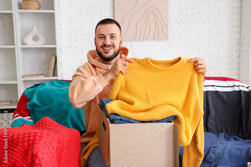 Smiling young man holding y...