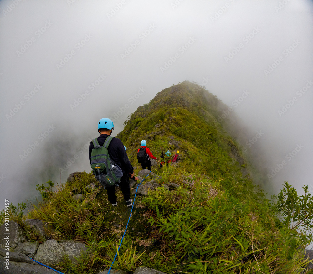 Obraz premium Asian people hiking a kelud mountain with a view of a misty mountain peak