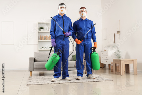 Male workers with disinfect...