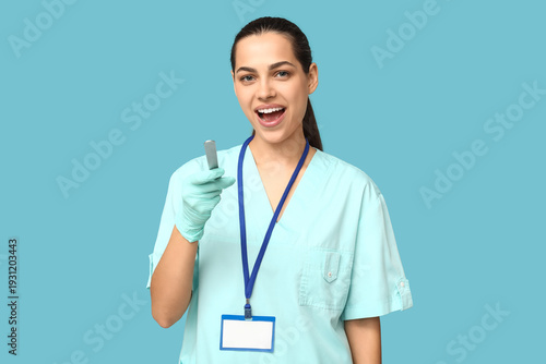 Portrait of female doctor with tongue depressor on blue background