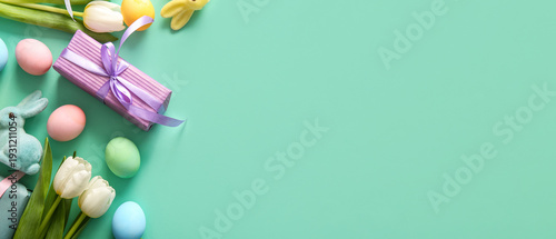 Easter eggs, tulip flowers with gift box and bunny on turquoise background