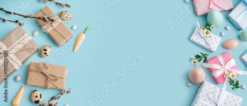 Easter gift boxes with eggs and branches of pussy willow on blue background