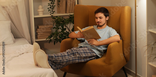 Young man reading book on a...