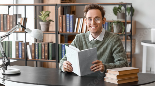 Young man reading book at t...