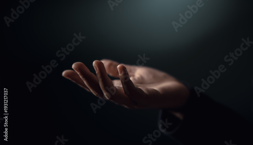 Open hand reaching in darkness. Concept of poverty, inequality, humanitarian aid