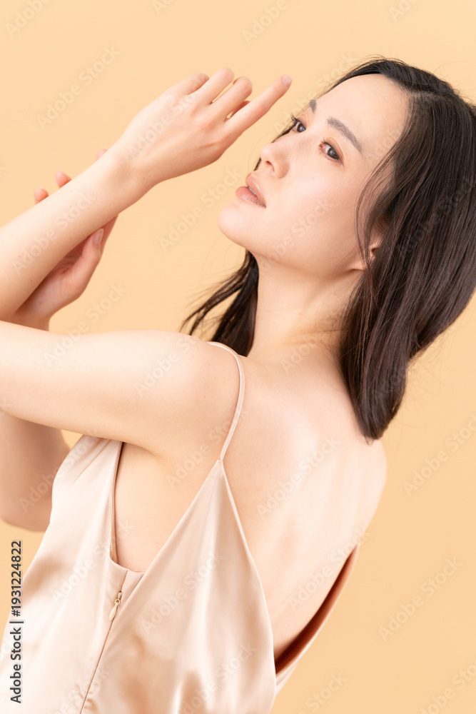 Obraz premium ベージュ背景でスキンケアをする女性のビューティーイメージ