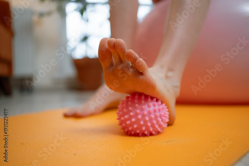 Fotografija Pregnant woman strengthening her feet and relieving discomfort by rolling a spik