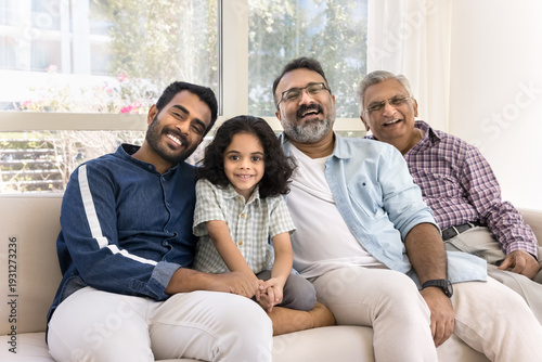 Foto Four generations of family sit together on couch, older male, younger man, and c
