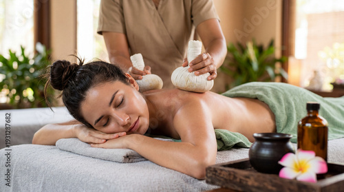 Traditional Ayurvedic Pindasweda massage therapy with warm herbal pouches in luxury spa wellness center