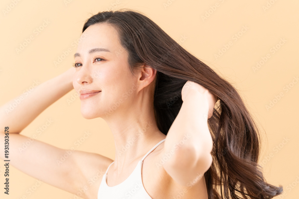 Obraz premium ベージュ背景でスキンケアをする女性のビューティーイメージ