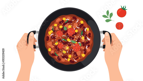 Overhead view of a pair of hands holding a black pot filled with spicy chili con carne with corn and tomatoes.