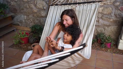 Mother and daughter playing together in a hammock