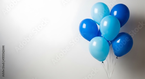 A cluster of blue balloons floating against a white background