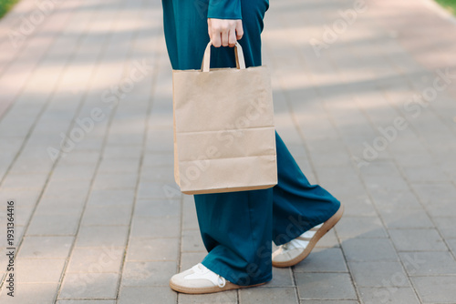 beige eco-friendly paper bag in woman hand, mockup, copy space