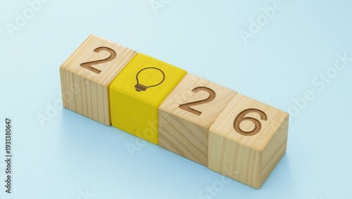 A wooden block calendar displaying the year 2026 with a lightbulb idea