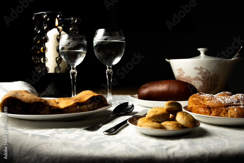 Mesa de comida mallorquina con espinagada, sobrasada, enseimada y galletas, con iluminación de vela.