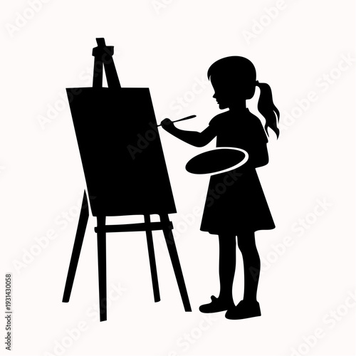Young girl standing beside an easel, painting on a canvas with a brush in hand, creative activity, studio setting