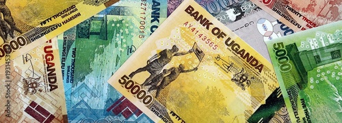 Fotografie Ugandan shilling paper banknotes pile on table
