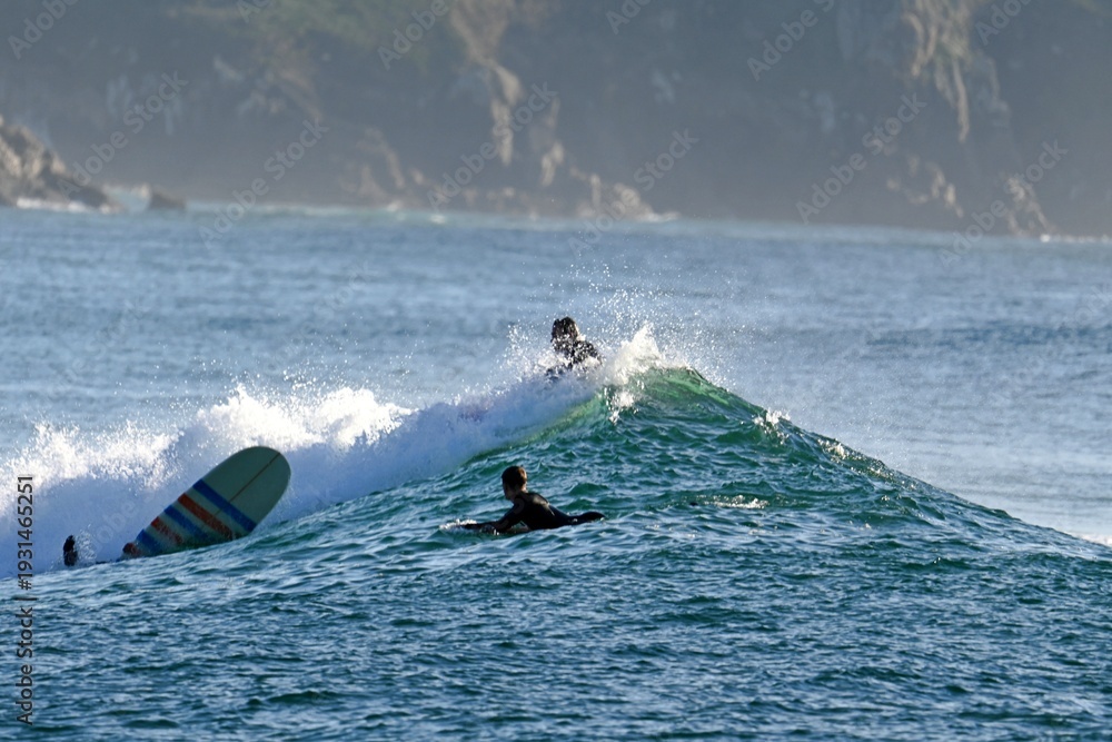 Obraz premium Wild Atlantic, landscape with surfers from Esmelle surf beach, Ferrol, Spain January 12, 2026