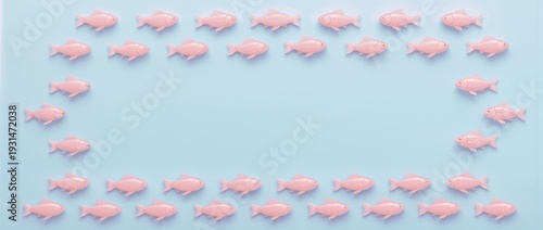Pastel pink fish arranged in rectangular frame on blue background. Minimal marine pattern with copy space, symbolizing organization, teamwork and creative design concept. Summer holidays theme

