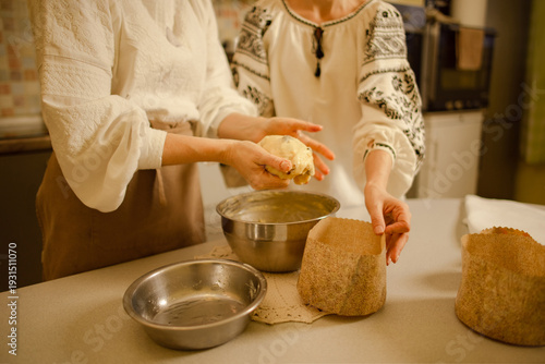 Ukrainian women cooking Easter cake at home, wearing traditional clothes vyshyvanka