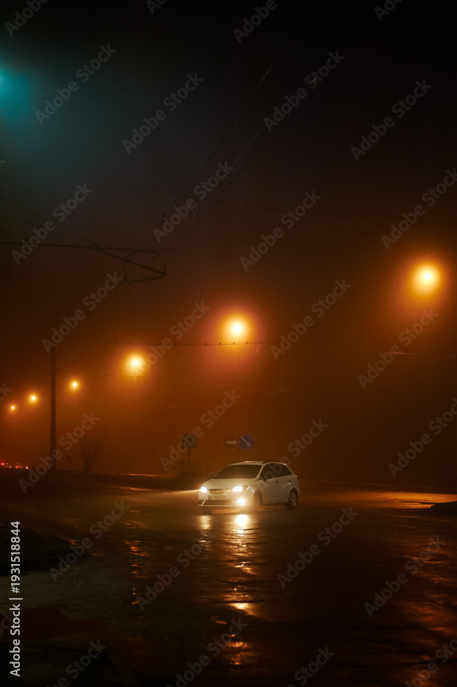 Fototapeta premium White car. Night street in the fog in the light of streetlights in the city, photo at night