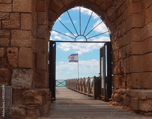 Ancient Stone Archway Gateway Frontal Blue Sky Flag. Historic Landmark Concept Travel Architecture Detail View