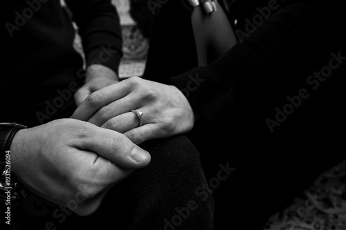 Photos Close-up black and white shot of a couple holding hands, woman wearing a diamond engagement ring