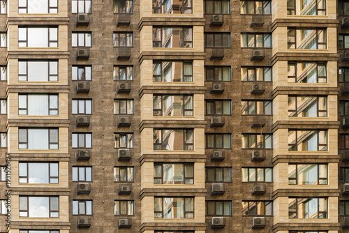Modern apartment building facade with repeating windows and air conditioning units