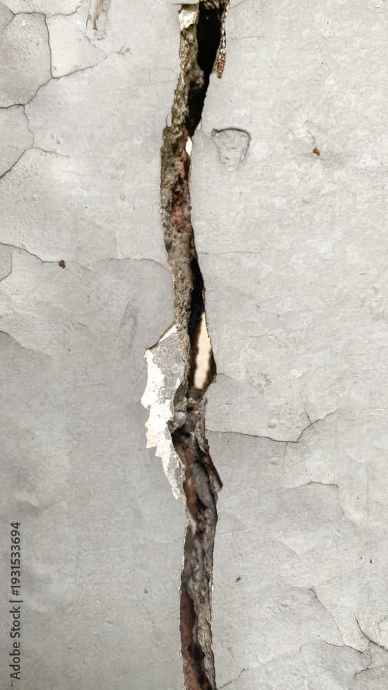 Fototapeta premium Gray wall concrete wall with big deep crack and some of the paint has peeled off.