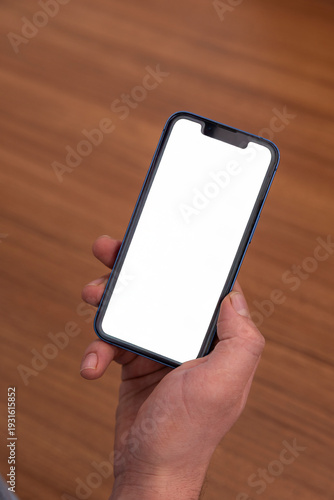 The man is holding a smartphone, from a high angle.