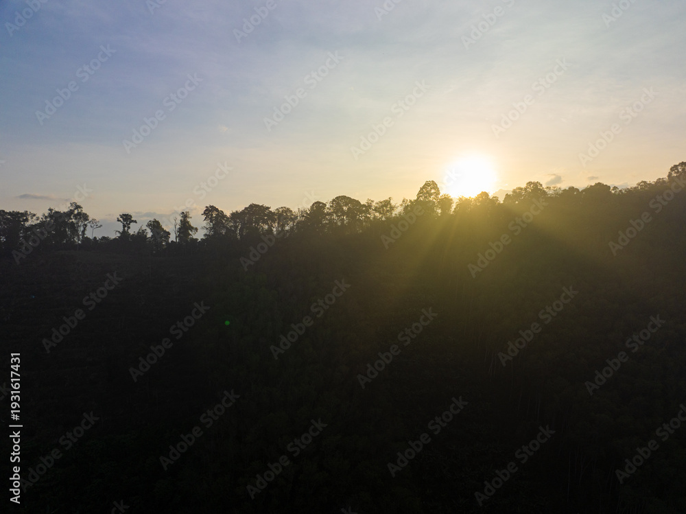 Obraz premium Aerial view mountain peak sunrise light on tropical rainforest sky with cloud