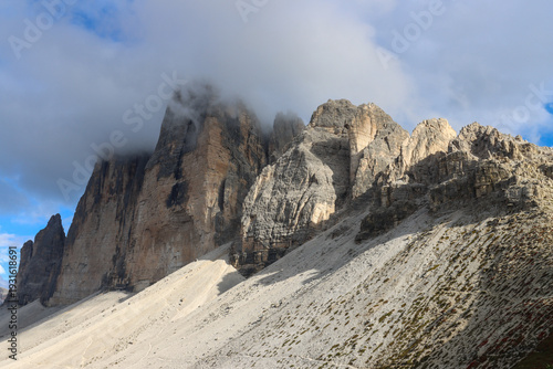 Rocky cliffs and alpine meadows surrounding the iconic Tre Cime di Lavaredo, a UNESCO World Heritage site in northern Italy
