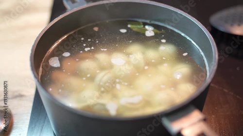 Dumplings are cooked in boiling water with salt and spices in a saucepan. They are semi-finished products designed for quick cooking.