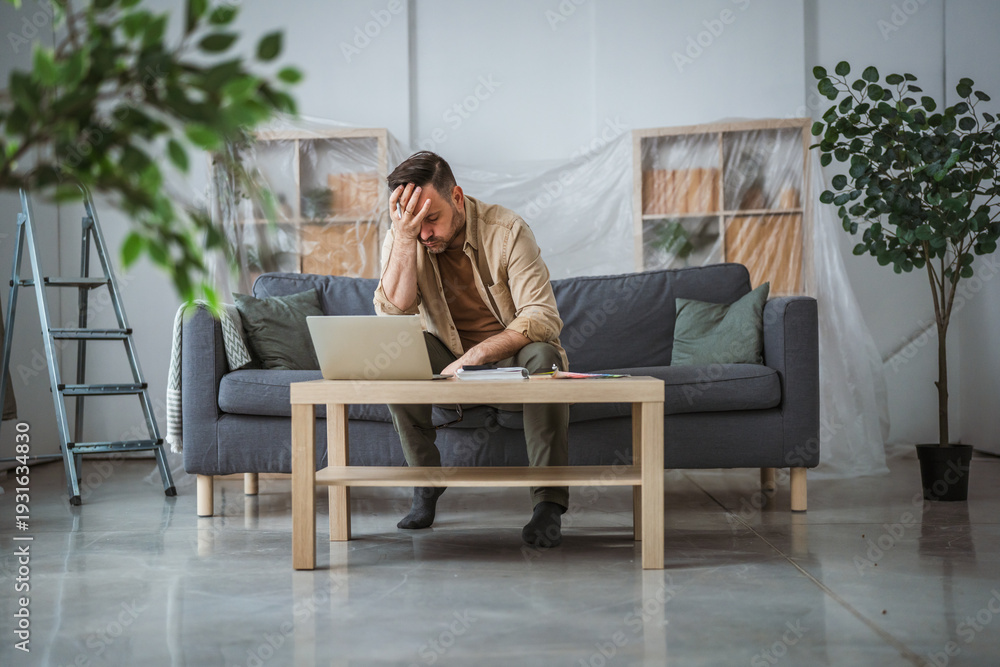 Fototapeta premium Man experiencing renovation stress and financial problems