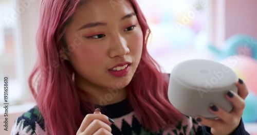 Young woman examining a skincare product indoors