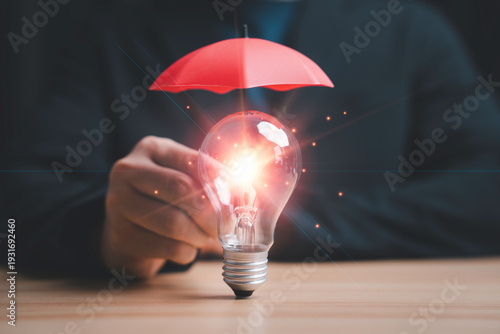 Copyright and patent protection concept with glowing light bulb under red umbrella, intellectual property security, legal rights protection, innovation safeguard and business risk management strategy.