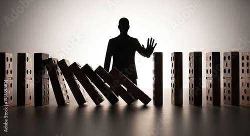 Silhouette of a person stopping falling dominoes symbolic of control